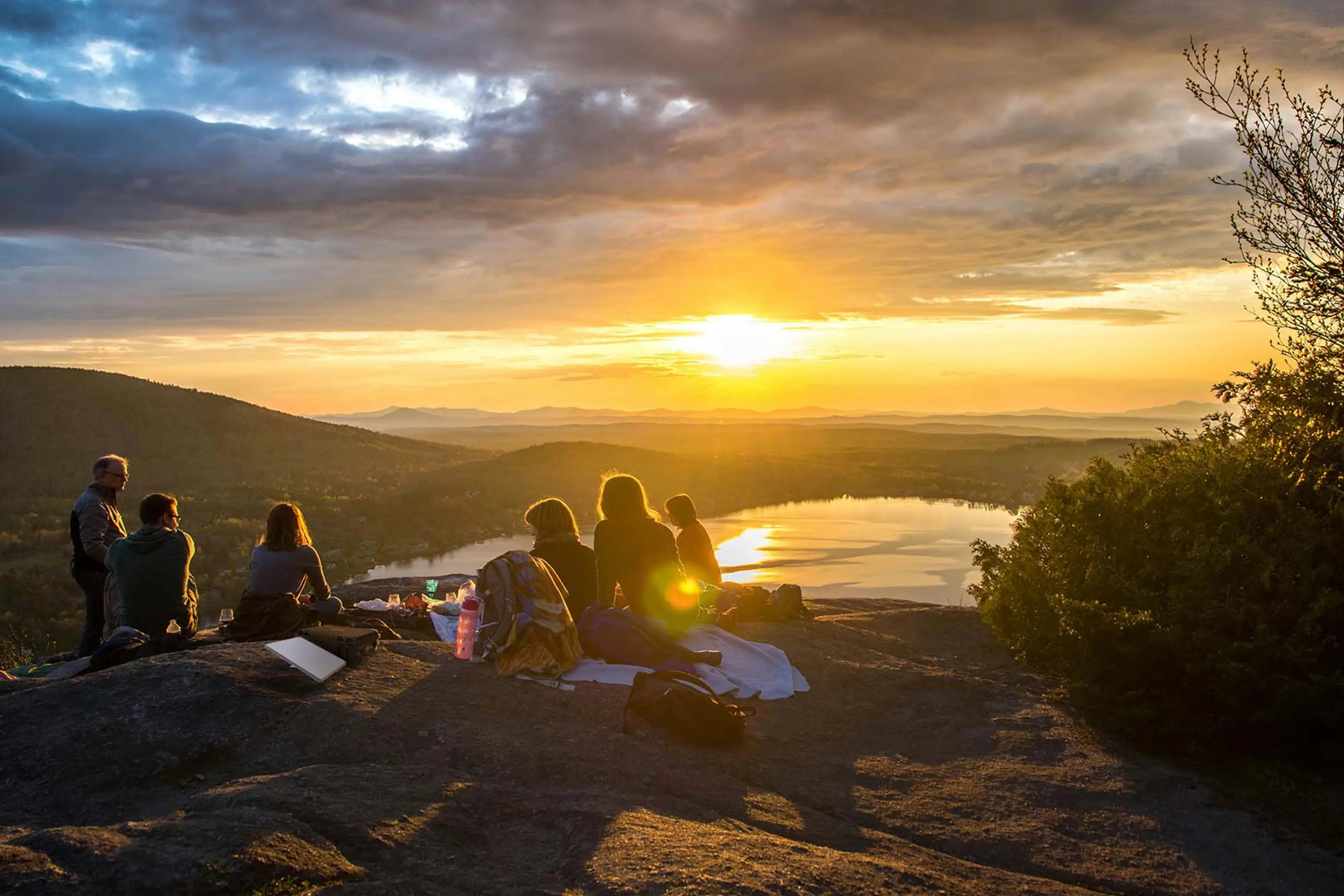Friends enjoying a mountain sunset with Starlink Mini providing portable off-grid internet for group adventures