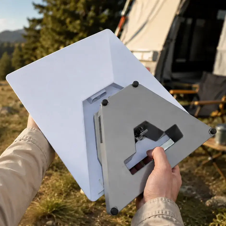 Close-up of a person carrying a Starlink Mini with an integrated LiFirst battery beside an RV campsite